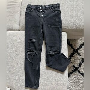 Black H&M jeans with rips and multiple buttons on front.